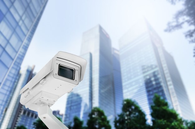 Cámara CCTV pública moderna en poste eléctrico con desenfoque de fondo del edificio