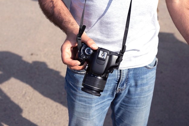 Foto cámara digital en la mano del hombre naturaleza de fondo