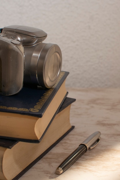 Cámara encima de algunos libros sobre una mesa de mármol con la luz del atardecer que entra por la ventana