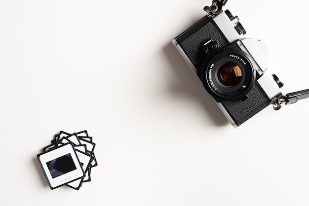 Cámara fotográfica vintage y un montón de transparencias en blanco con espacio para copiar