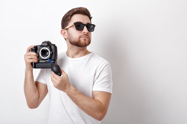 Cámara de limpieza de joven fotógrafo con bomba de vacío. limpiador de polvo con soplador de mano para cámaras y lentes.