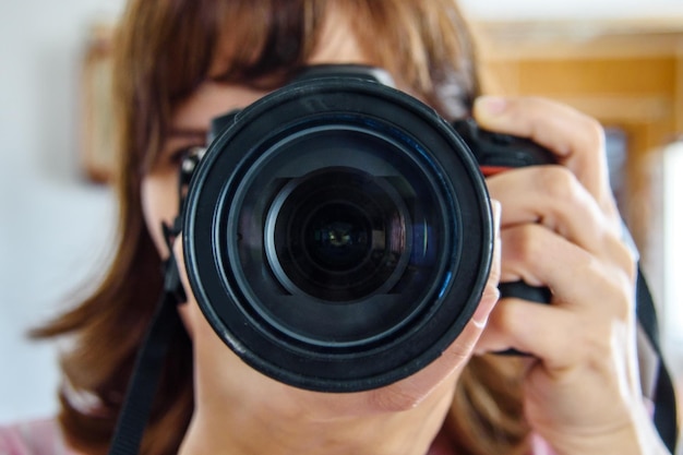 Cámara en manos de una fotógrafa con lentes de cara completa