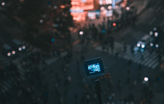Foto cámara en monopodo sobre la carretera en la ciudad por la noche