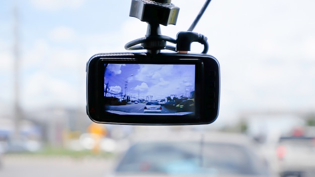 Foto cámara en la parte delantera de un automóvil antecedentes coches en la carretera y nubes en el cielo.