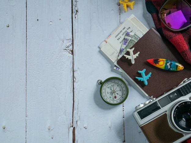 Foto la cámara y el pasaporte en la mesa de madera por concepto de viaje.