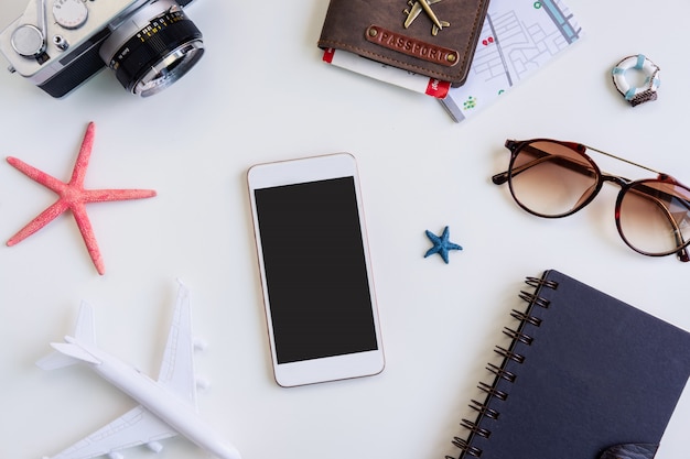 Cámara retro con avión de juguete y teléfono inteligente con pantalla vacía