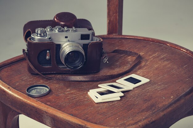 Foto cámara retro y viejas diapositivas yacían en una silla