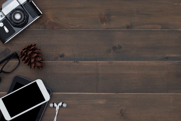 Cámara, teléfono inteligente, tableta, auricular y gafas en madera.