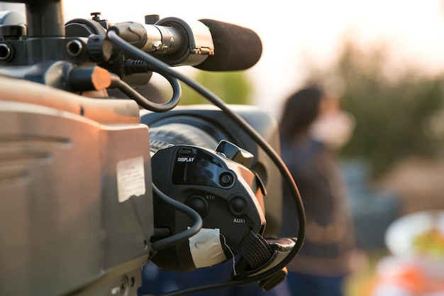 Cámara de televisión y presentador en una transmisión de noticias en vivo en el lugar al amanecer