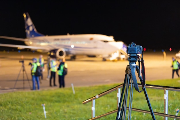 Cámara en trípode durante el avistamiento en el aeropuerto por la noche