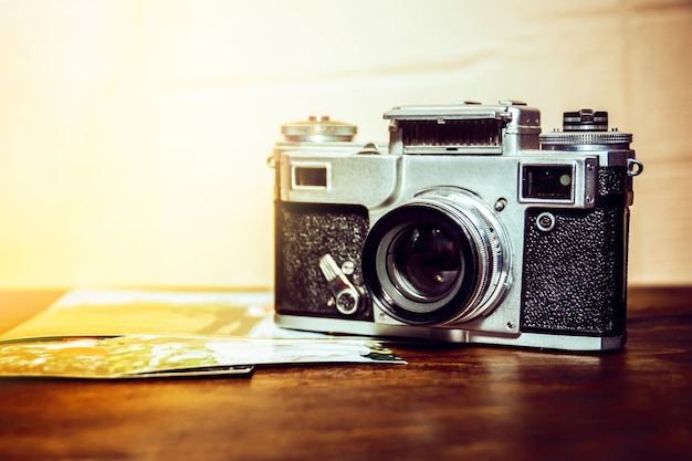 La cámara vieja está sobre la mesa en una pila de fotos