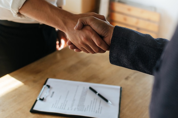 Camaradería. Apretón de manos de dos empresarios después de firmar un contrato comercial en la oficina de la sala de reuniones