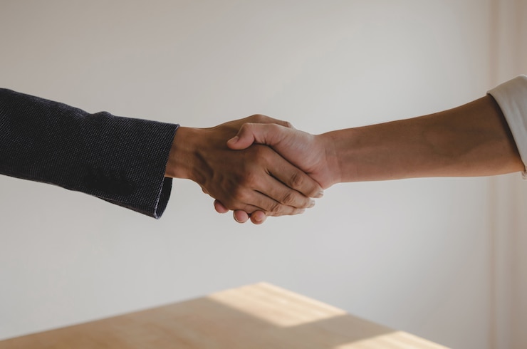 Foto camaradería. dos empresarios estrecharme la mano después de firmar un contrato comercial