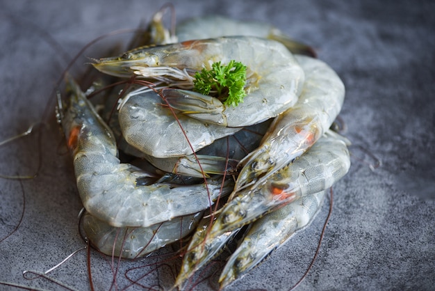 Camarão cru com temperos de ervas no prato escuro - camarão fresco no restaurante ou mercado de frutos do mar