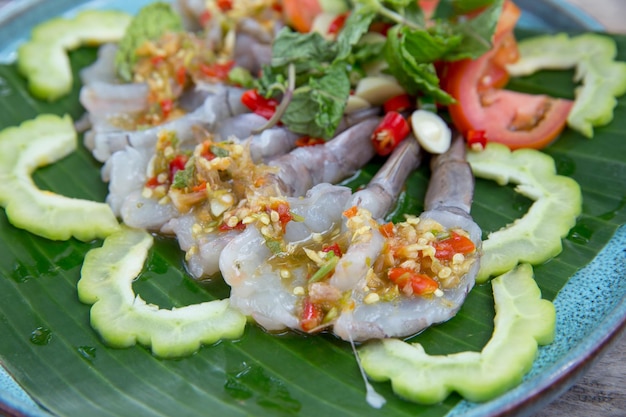 Foto camarão em molho de peixe em folha de banana com molho de frutos do mar