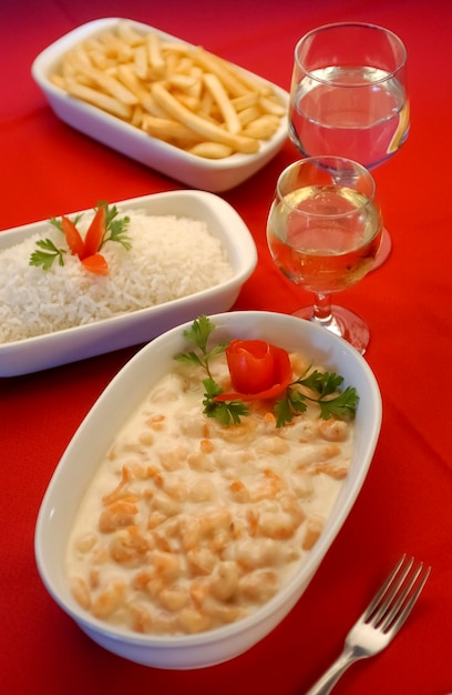 Camarão em molho de queijo branco em tigela branca na toalha de mesa vermelha