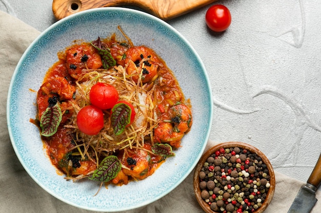 Camarão grelhado com molho de tomate e arroz fecha no prato na mesa de concreto com ingredientes no fundo