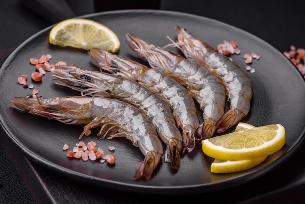 Camarão tigre ou lagostim cru com especiarias e sal numa tábua de madeira