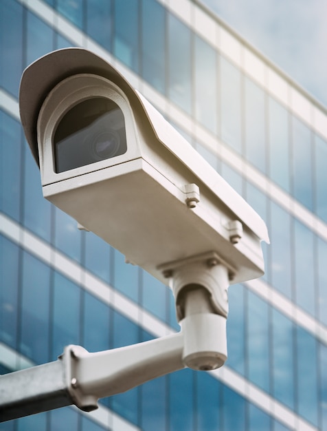 Cámaras de seguridad con un edificio de cristal en el fondo