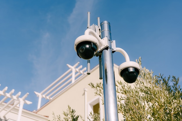 Cámaras de vigilancia radiocontroladas con forma de cúpula negra en un poste con el telón de fondo de la