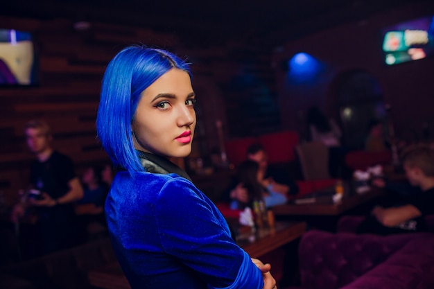 Camarera con cabello azul en un bar