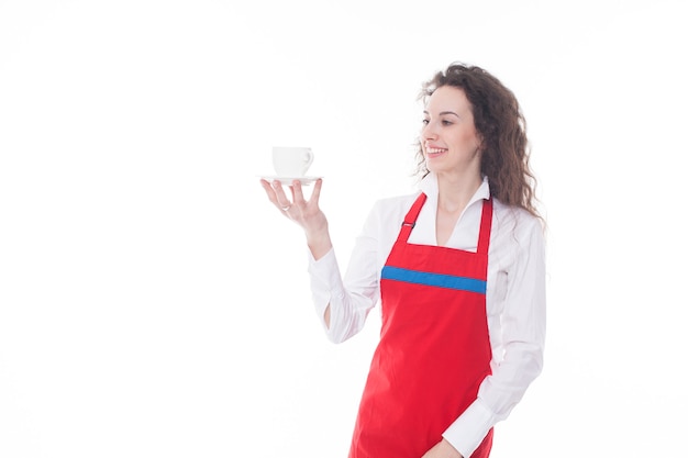 Camarera en delantal rojo ofreciendo una taza de café aislado sobre fondo blanco.