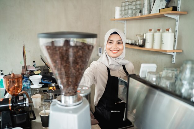 Camarera mujer sosteniendo un molinillo de café