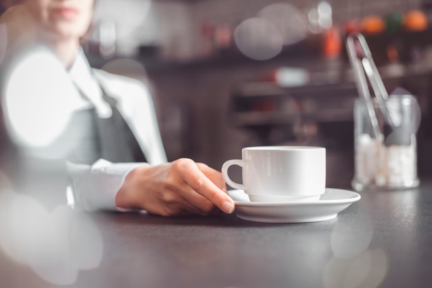 Camarera que sirve una taza de café a un cliente en un café