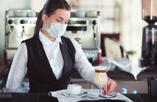 Foto la camarera sirve café con leche en un vaso