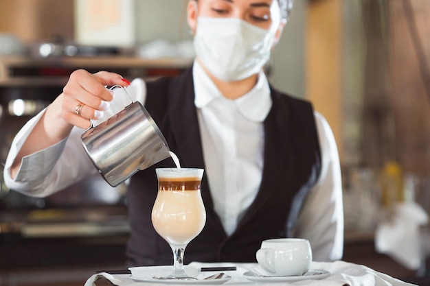 la camarera sirve café con leche en un vaso