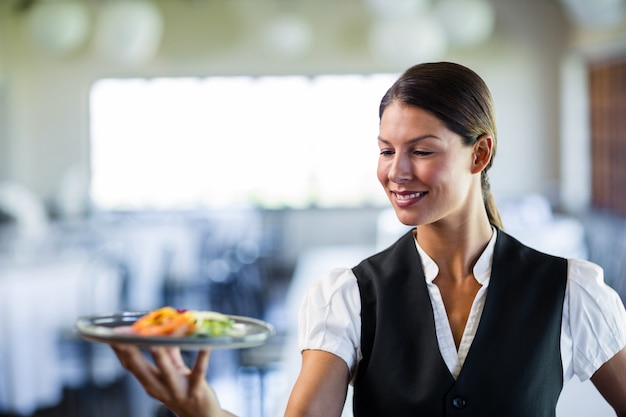 Camarera sosteniendo un plato en un restaurante