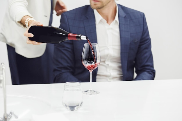 Foto la camarera vierte vino rojo para el sommelier durante el concurso de degustación de cerca