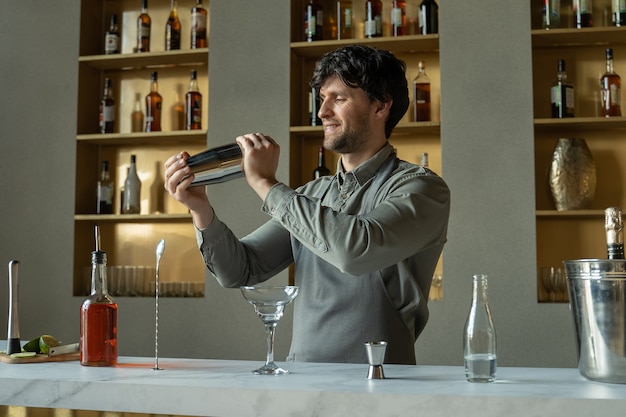 Camarero agitando la coctelera en el bar de cócteles