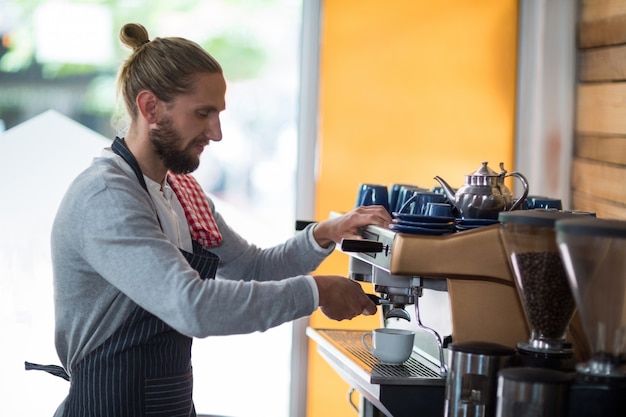 Camarero atento haciendo una taza de café