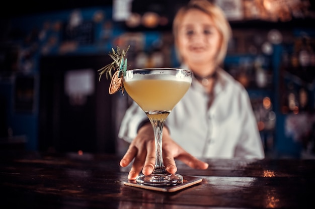 Camarero chica prepara un cóctel en la cervecería