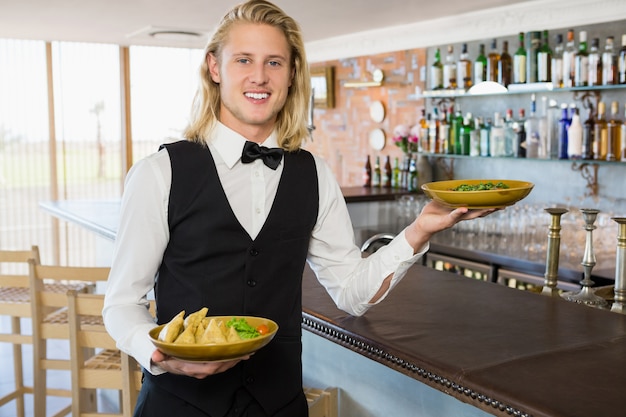 Camarero con comidas en el restaurante