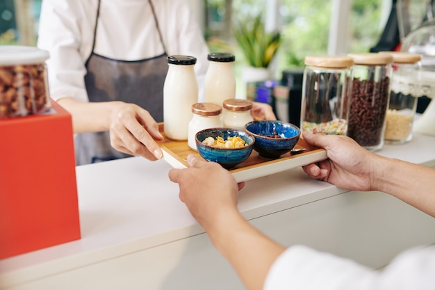 Camarero dando bandeja con desayuno al cliente