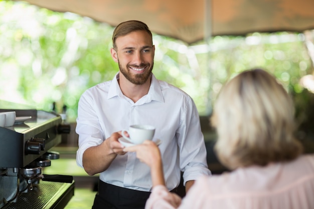 Camarero dando café al cliente