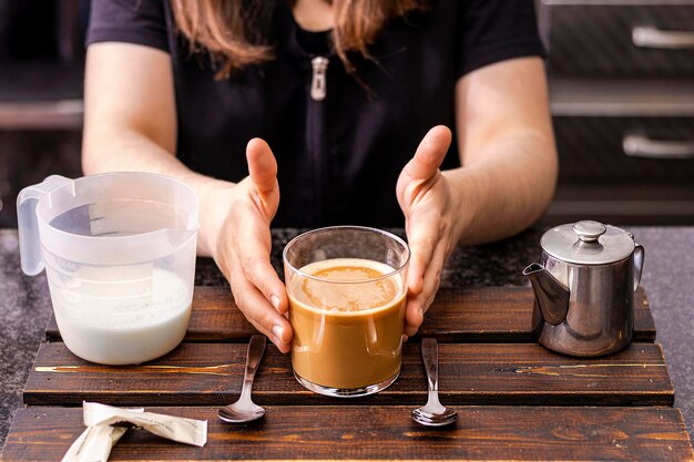 Camarero en delantal negro se extiende una taza de café