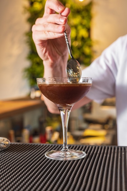 El camarero detrás de la barra hace un espresso martini