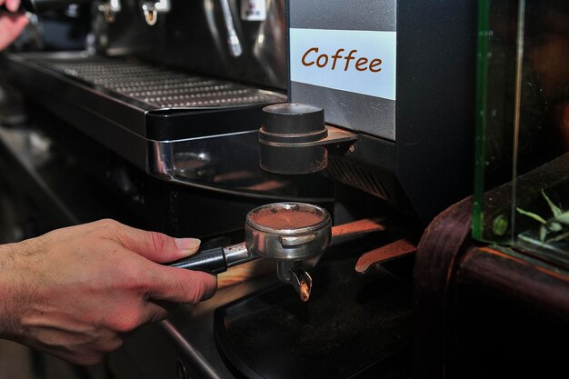 El camarero hace un café en la máquina de espresso.