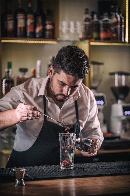 Camarero hace cóctel de granada sin alcohol