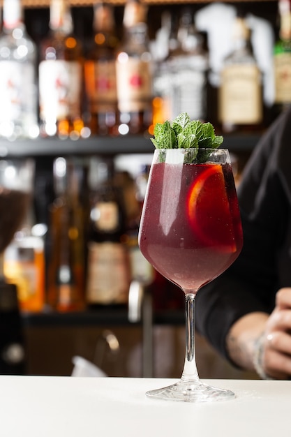 Camarero haciendo sangría roja en el restaurante italiano cóctel de sangría con vino tinto en la barra borrosa