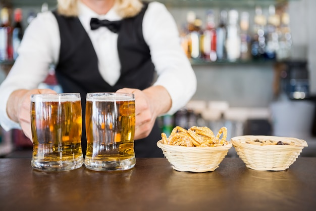 Camarero con jarra de cerveza en el mostrador