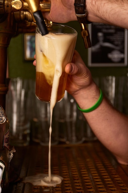 Camarero de mano vertiendo cerveza lager grande Cerveza filtrada fría ligera en vaso de precipitados