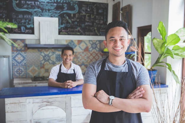 Foto camarero masculino de pie con los brazos cruzados en cafe