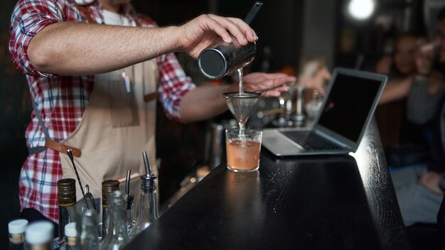 Foto camarero masculino sirviendo un cóctel de un mejor servicio de coctelera