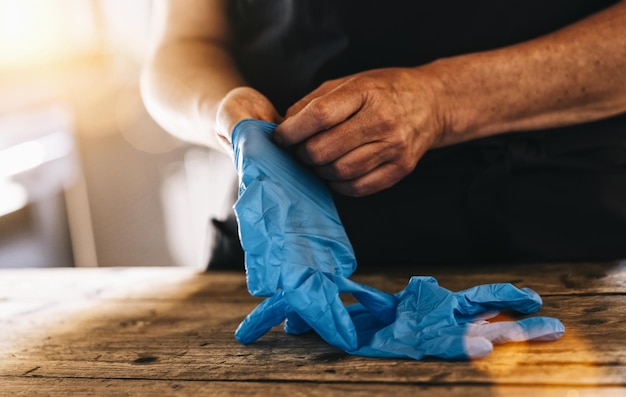 Foto camarero o empleado que usa guantes médicos de látex en el trabajo para prevenir la infección por corona covid19 y sars