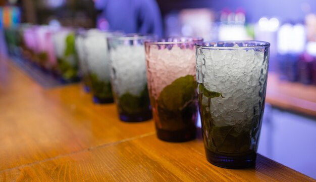 Camarero poniendo cal en vaso. Machacar lima para hacer un cóctel. Camarero sosteniendo un vaso.