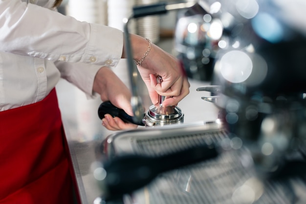 Camarero preparando café en una cafetera automática